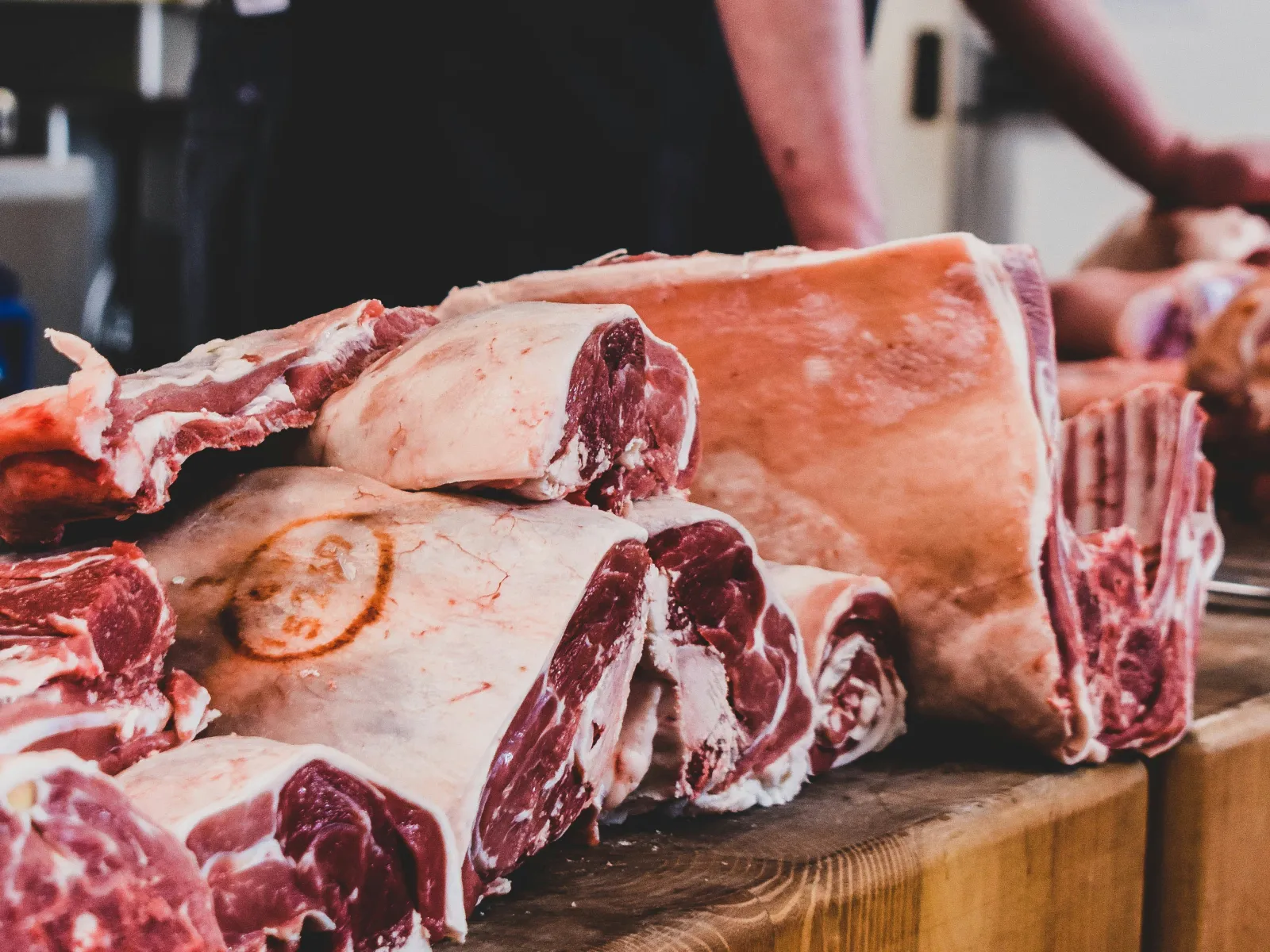 Fresh cuts of meat on a butcher block in a processing room